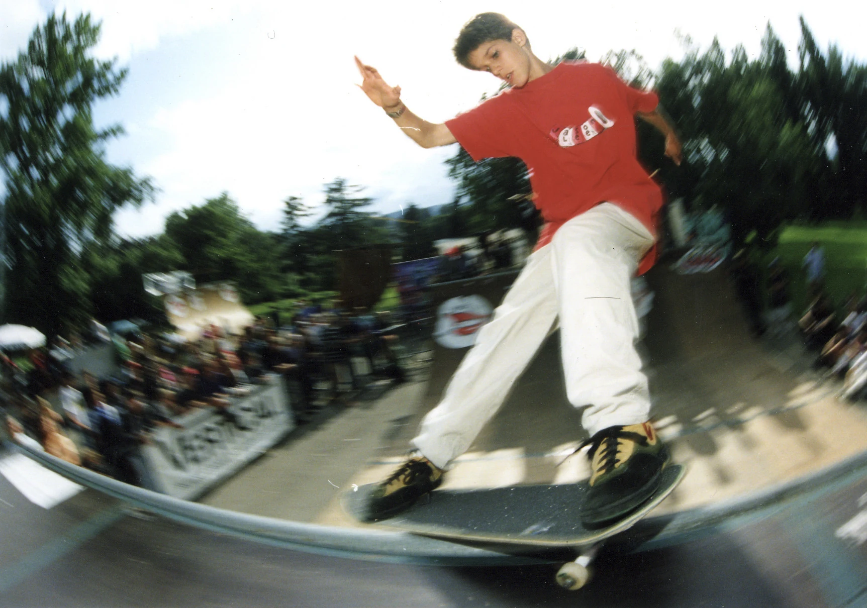 Skateboarder im roten Shirt beim Frontside Smith Grind am Coping einer Minirampe auf der Landiwiese in Zürich.