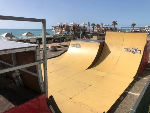 Mobile Quarterpipes von Vertical Technik mit gelben Fahrflächen und direktem Blick auf die Meeresküste.